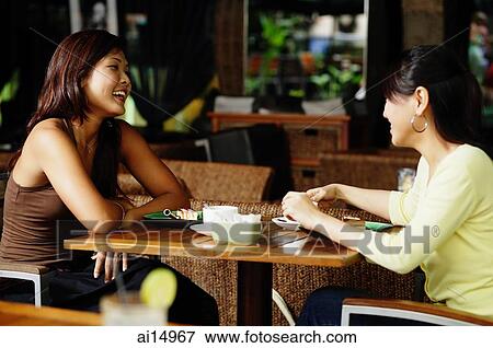 Young women sitting at cafe View Large Photo Image Stock Photo - Young women sitting at cafe. Fotosearch