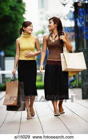 Young women walking side by side View Large Photo Image Stock Photo - Young women walking side by side. Fotosearch