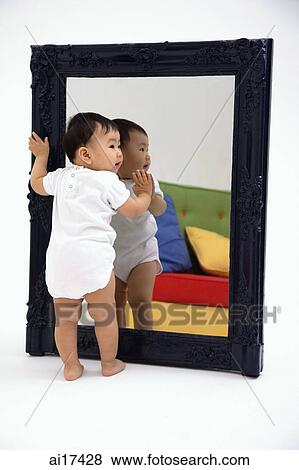 Baby boy standing against mirror View Large Photo Image Stock Photo - Baby boy standing against mirror . Fotosearch
