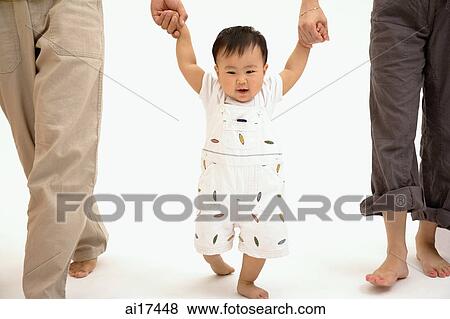 Baby boy walking between his parents View Large Photo Image Stock Photo - Baby boy walking between his parents . Fotosearch
