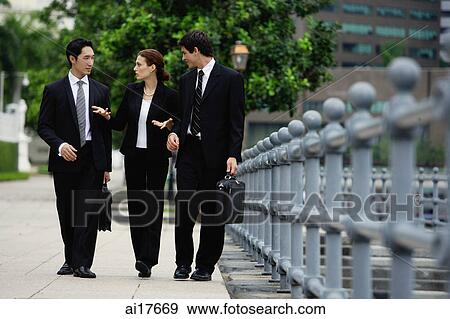 Business people walking in a row, talking View Large Photo Image Stock Photo - Business people walking in a row, talking . Fotosearch