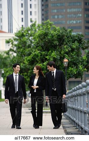 Business people walking side by side, talking View Large Photo Image Stock Photo - Business people walking side by side, talking . Fotosearch