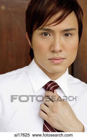 Businessman adjusting tie, looking at camera View Large Photo Image Stock Photography - Businessman adjusting tie, looking at camera . Fotosearch