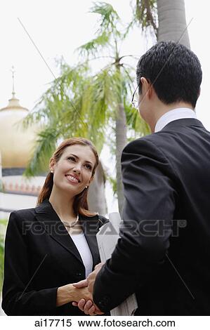 Stock Photography - Businessman and businesswoman shaking hands. Fotosearch