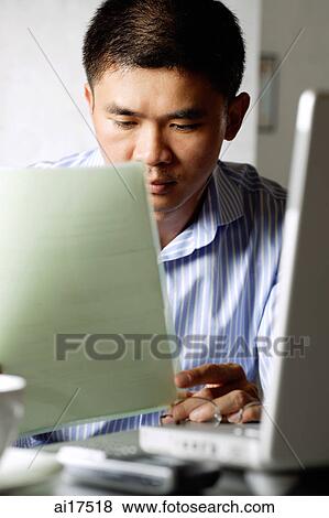 Businessman looking at document View Large Photo Image Stock Photo - Businessman looking at document. Fotosearch