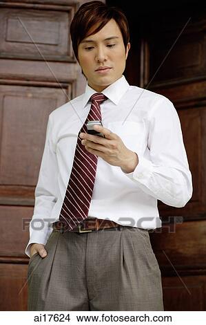 Businessman looking at mobile phone View Large Photo Image Picture - Businessman looking at mobile phone . Fotosearch