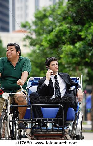 Businessman on trishaw, using mobile phone View Large Photo Image Stock Image - Businessman on trishaw, using mobile phone . Fotosearch