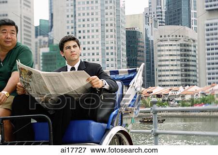 Businessman sitting in trishaw, holding newspaper View Large Photo Image Stock Photo - Businessman sitting in trishaw, holding newspaper . Fotosearch
