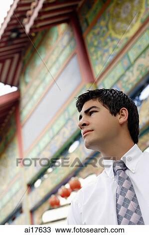 Businessman standing in front of temple gate, looking away, head shot View Large Photo Image Stock Image - Businessman standing in front of temple gate, looking away, head shot . Fotosearch