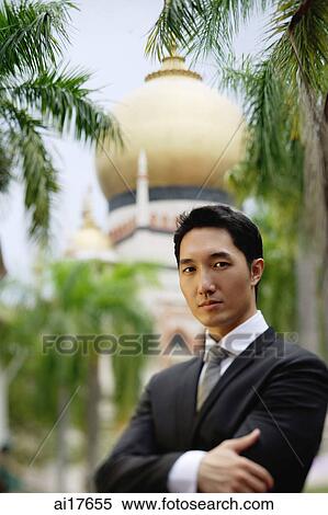 Businessman standing with arms crossed, mosque in the background View Large Photo Image Stock Photography - Businessman standing with arms crossed, mosque in the background . Fotosearch