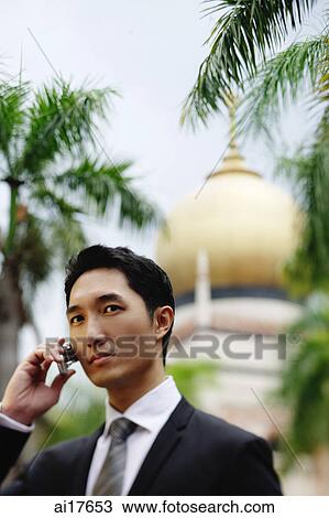 Businessman using mobile phone, mosque in the background View Large Photo Image Stock Image - Businessman using mobile phone, mosque in the background . Fotosearch