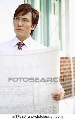 Businessman with blueprints View Large Photo Image Stock Photograph - Businessman with blueprints . Fotosearch