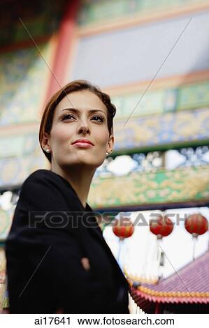 Businesswoman looking away, temple gates in the background View Large Photo Image Stock Image - Businesswoman looking away, temple gates in the background . Fotosearch
