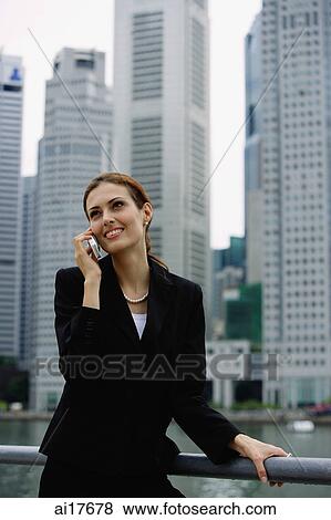 Businesswoman on mobile phone, river and buildings in the background View Large Photo Image Stock Photo - Businesswoman on mobile phone, river and buildings in the background . Fotosearch