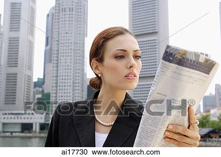 Businesswoman reading newspaper, buildings in the background View Large Photo Image Stock Image - Businesswoman reading newspaper, buildings in the background . Fotosearch