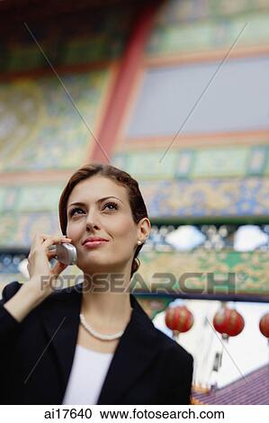 Stock Image - Businesswoman using mobile phone, portrait . Fotosearch