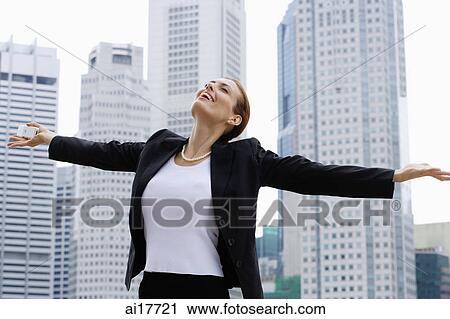 Businesswoman with arms outstretched, looking up View Large Photo Image Stock Image - Businesswoman with arms outstretched, looking up. Fotosearch