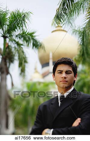 Caucasian businessman standing with arms crossed, mosque in the background View Large Photo Image Stock Photograph - Caucasian businessman standing with arms crossed, mosque in the background . Fotosearch