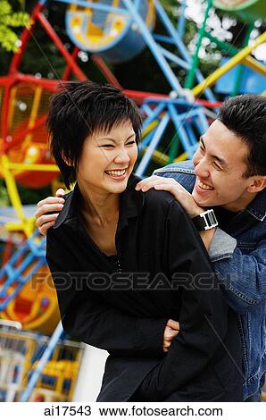 Stock Image - Couple at playground, laughing . Fotosearch