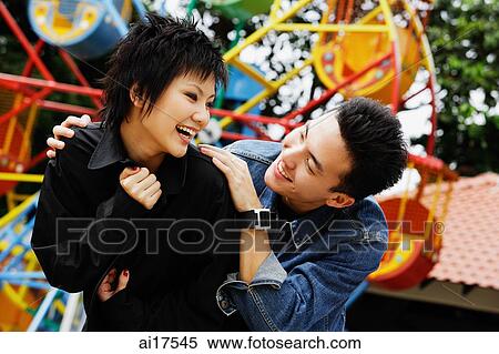 Couple at playground, looking at each other, laughing View Large Photo Image Stock Photography - Couple at playground, looking at each other, laughing . Fotosearch