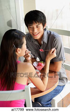 Couple eating dessert at a cafe View Large Photo Image Stock Photo - Couple eating dessert at a cafe . Fotosearch