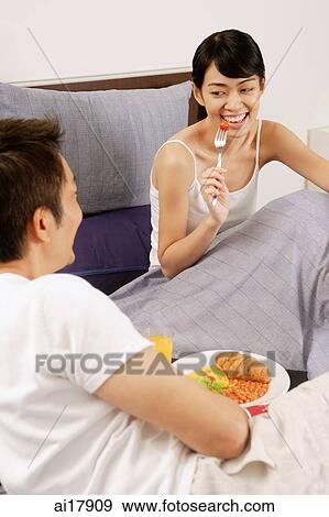 Couple having breakfast in bed View Large Photo Image Stock Photo - Couple having breakfast in bed . Fotosearch