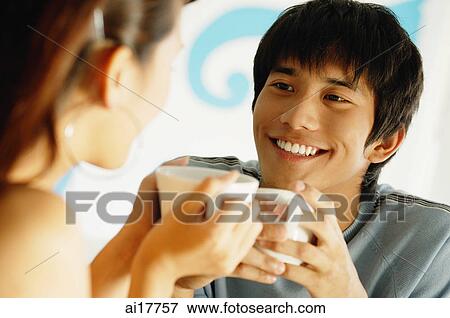 Stock Photo - Couple having coffee, looking at each other. Fotosearch