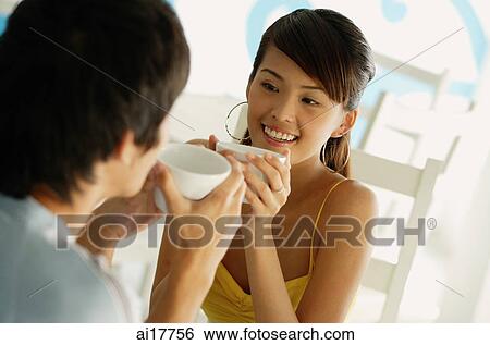 Stock Photograph - Couple having coffee, sitting face to face. Fotosearch
