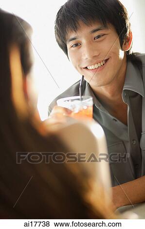 Couple having drinks, sitting face to face View Large Photo Image Stock Photo - Couple having drinks, sitting face to face. Fotosearch