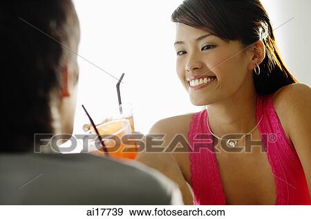 Couple having drinks, sitting face to face View Large Photo Image Stock Photo - Couple having drinks, sitting face to face . Fotosearch