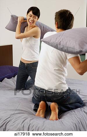 Couple having pillow fight in bedroom View Large Photo Image Stock Photo - Couple having pillow fight in bedroom . Fotosearch