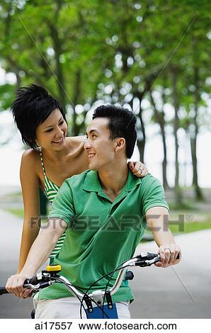 Couple on tandem bicycle, looking at each other View Large Photo Image Stock Photo - Couple on tandem bicycle, looking at each other. Fotosearch