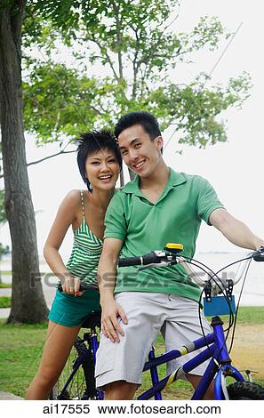 Couple on tandem bicycle, looking at camera View Large Photo Image Stock Photography - Couple on tandem bicycle, looking at camera. Fotosearch