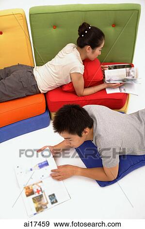 Couple reading magazines in living room View Large Photo Image Stock Photo - Couple reading magazines in living room . Fotosearch