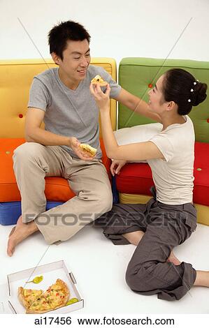 Couple sharing a pizza, woman feeding man View Large Photo Image Stock Photograph - Couple sharing a pizza, woman feeding man . Fotosearch