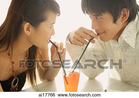 Couple sharing one drink, sitting face to face View Large Photo Image Stock Photograph - Couple sharing one drink, sitting face to face. Fotosearch