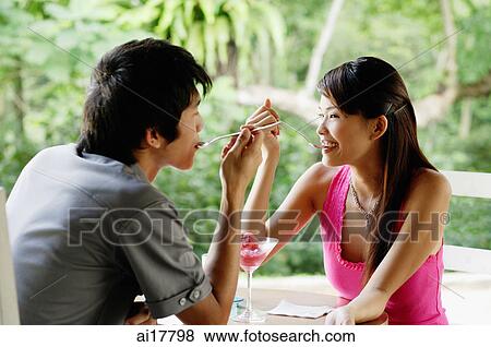 Couple sitting at cafe eating dessert View Large Photo Image Stock Photo - Couple sitting at cafe eating dessert . Fotosearch