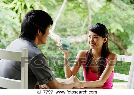 Couple sitting at cafe having drinks View Large Photo Image Stock Photo - Couple sitting at cafe having drinks . Fotosearch