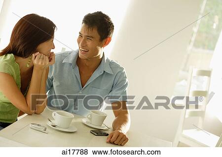 Couple sitting at cafe, side by side, smiling View Large Photo Image Stock Photo - Couple sitting at cafe, side by side, smiling . Fotosearch