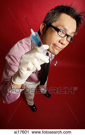 Doctor holding out syringe View Large Photo Image Stock Image - Doctor holding out syringe. Fotosearch
