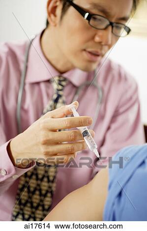 Doctor injecting patient View Large Photo Image Picture - Doctor injecting patient . Fotosearch