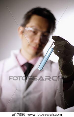 Doctor looking at test tube View Large Photo Image Stock Photograph - Doctor looking at test tube. Fotosearch
