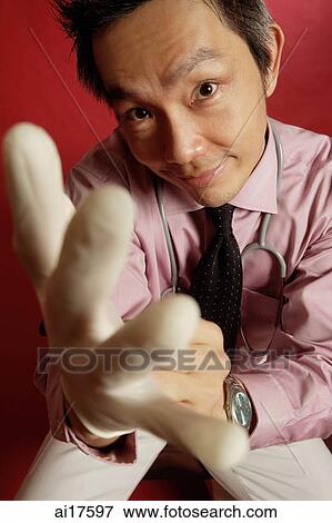 Stock Photo - Doctor putting on gloves . Fotosearch