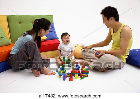 Family with one child, playing with toys, sitting on living room floor View Large Photo Image Stock Image - Family with one child, playing with toys, sitting on living room floor . Fotosearch
