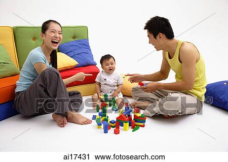Family with one child, sitting on floor, playing with toys View Large Photo Image Stock Image - Family with one child, sitting on floor, playing with toys . Fotosearch