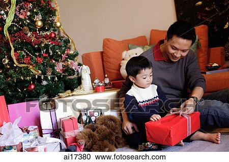 Father and son opening gifts on Christmas View Large Photo Image Stock Image - Father and son opening gifts on Christmas. Fotosearch