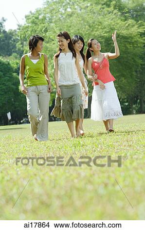 Picture - Four young women walking in park . Fotosearch