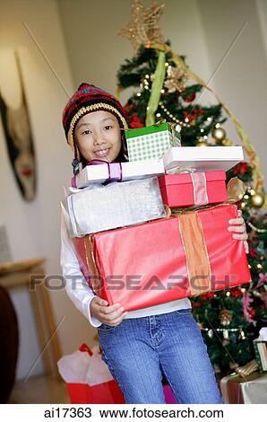 Girl holding pile of Christmas gifts View Large Photo Image Stock Image - Girl holding pile of Christmas gifts . Fotosearch