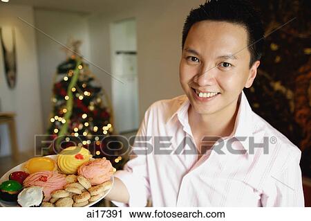 Man holding a plate of food, smiling at camera View Large Photo Image Stock Image - Man holding a plate of food, smiling at camera . Fotosearch