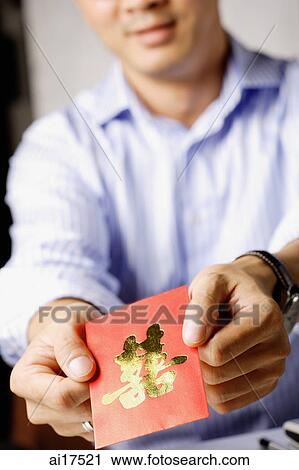 Man holding red packet with Chinese calligraphy meaning Joyous View Large Photo Image Stock Image - Man holding red packet with Chinese calligraphy meaning Joyous. Fotosearch